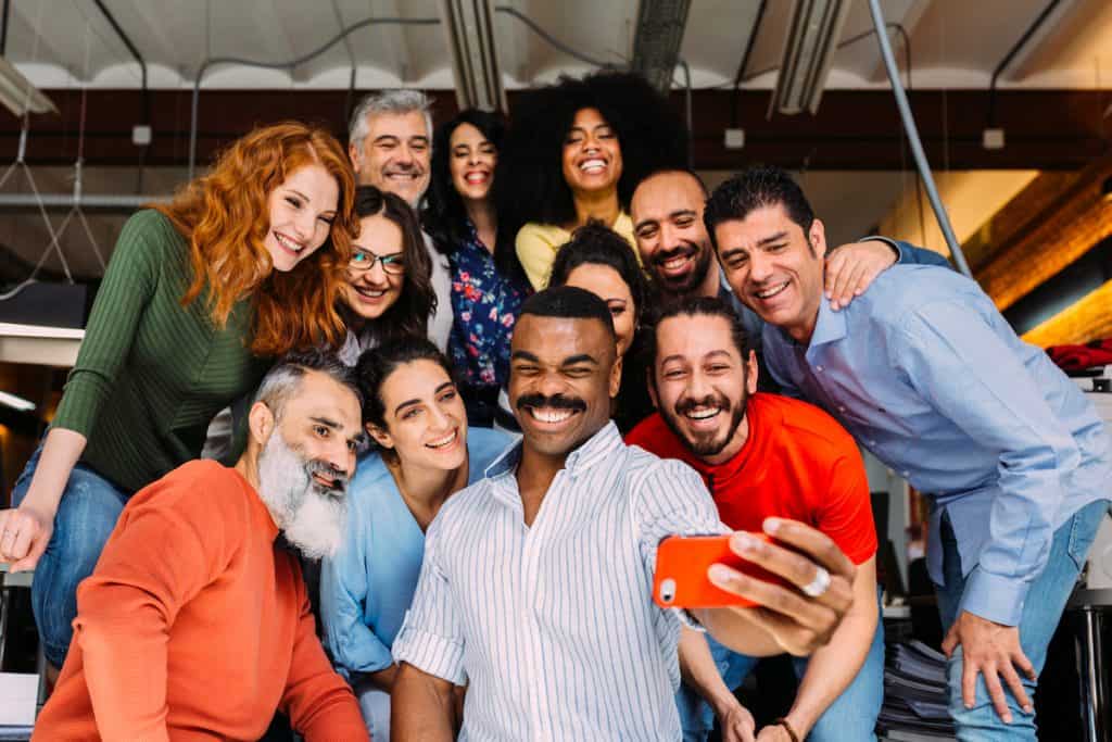 Diverse group of people smile and pose for selfie